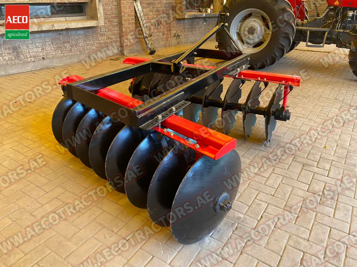 Heavy-duty Aeco 18 disc harrow attached to a tractor, working efficiently on a large farm field.